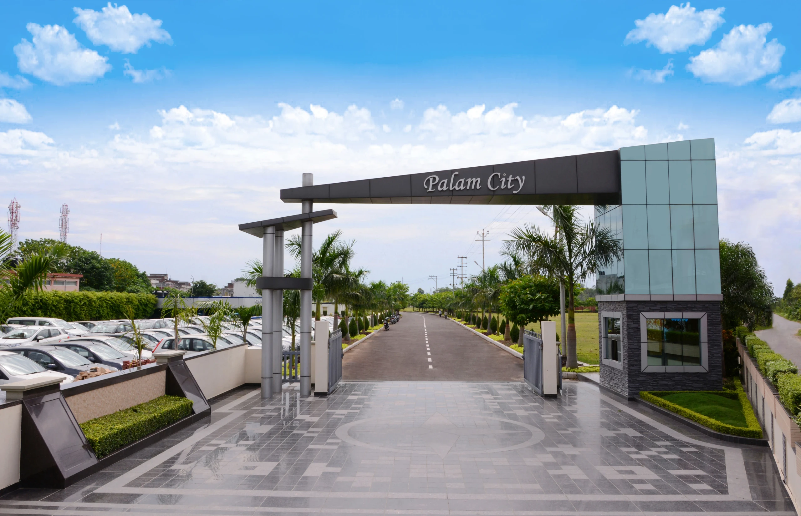 Palam City's gated entrance opening onto a landscaped avenue