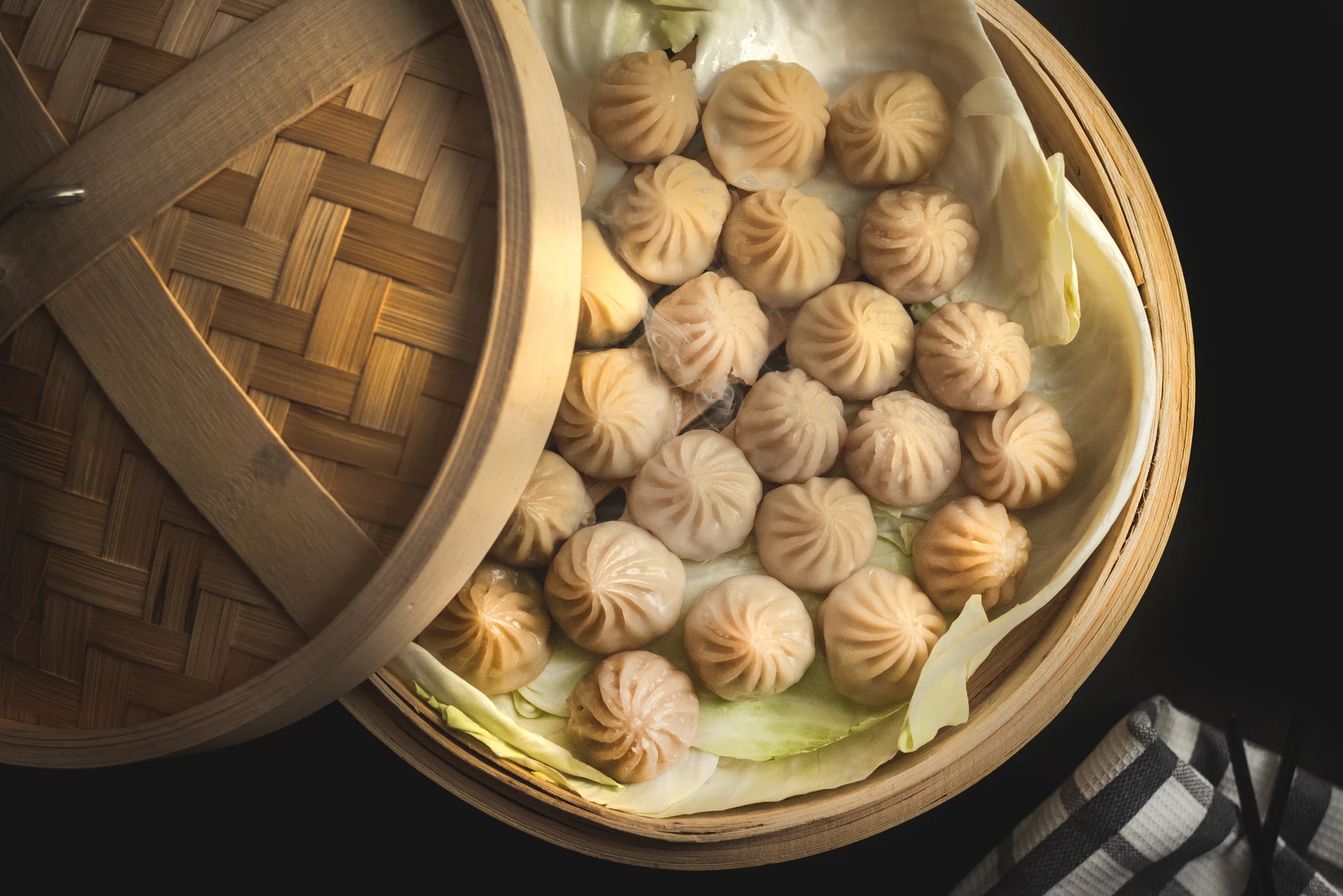 Steamed vegetable momos arranged inside a bamboo steamer
